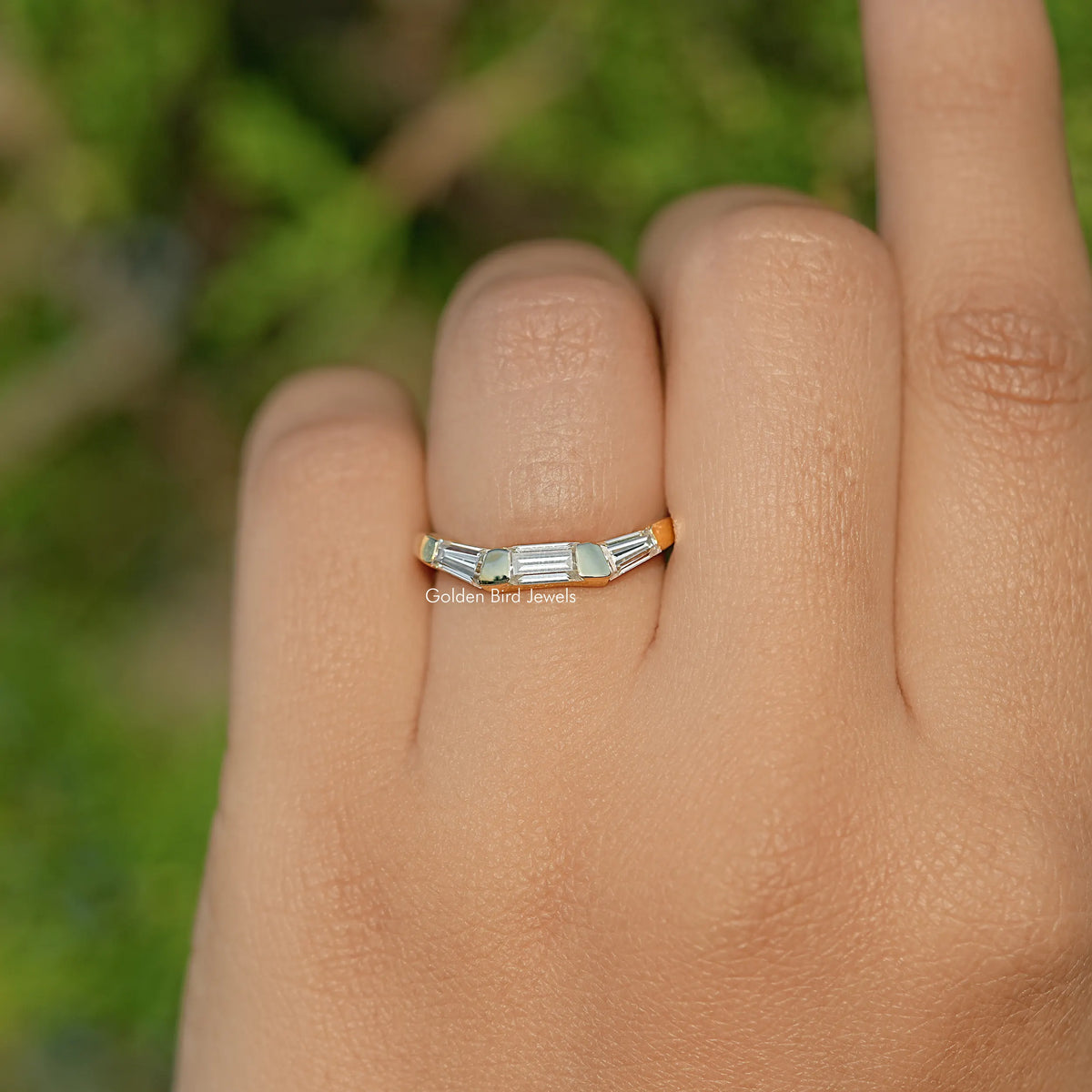 Three-stone baguette-cut moissanite ring on hand, centered stones visible