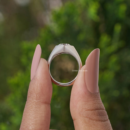 Silver engagement ring underside view, held between fingertips