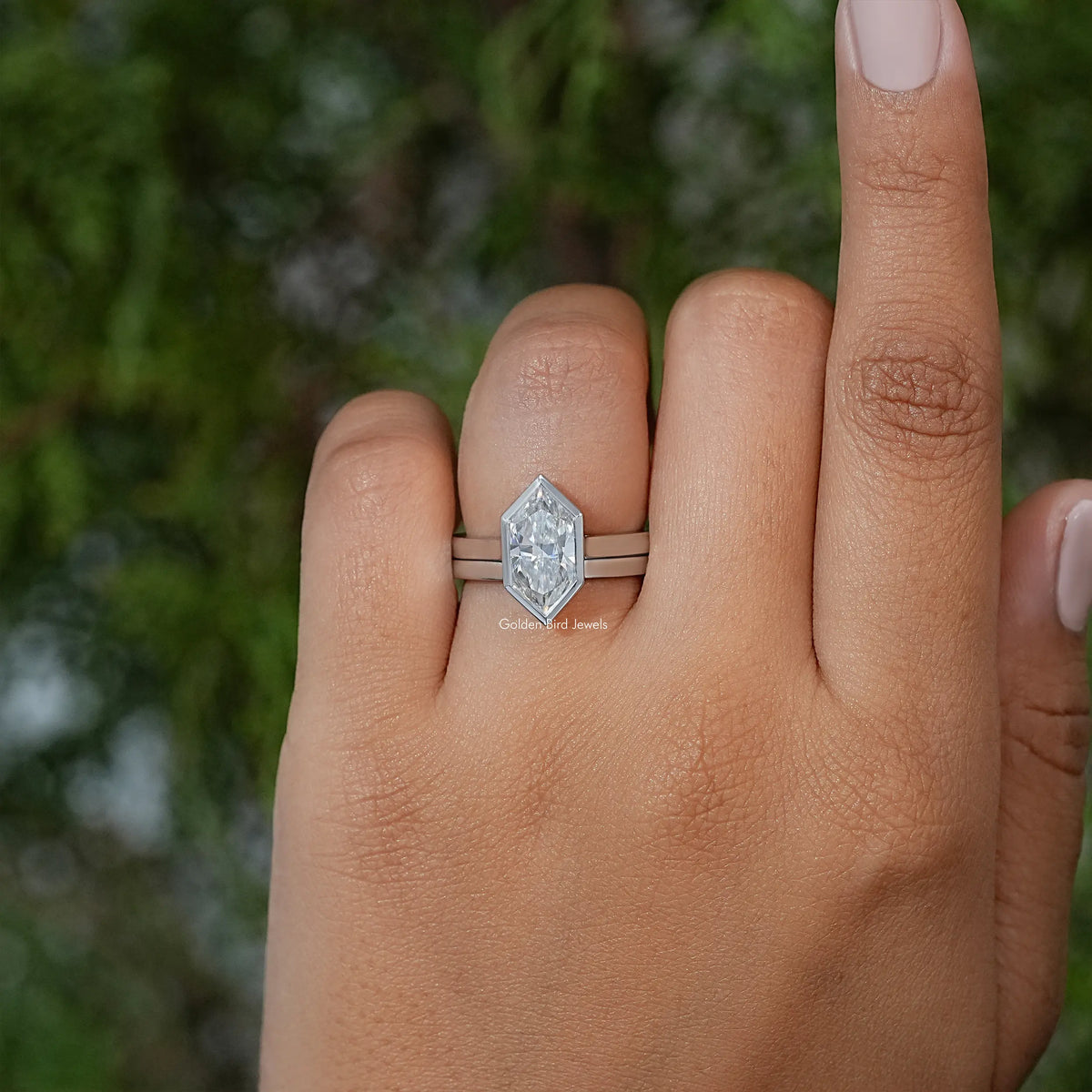Marquise bezel ring set on hand, silver-tone band with marquise center stone