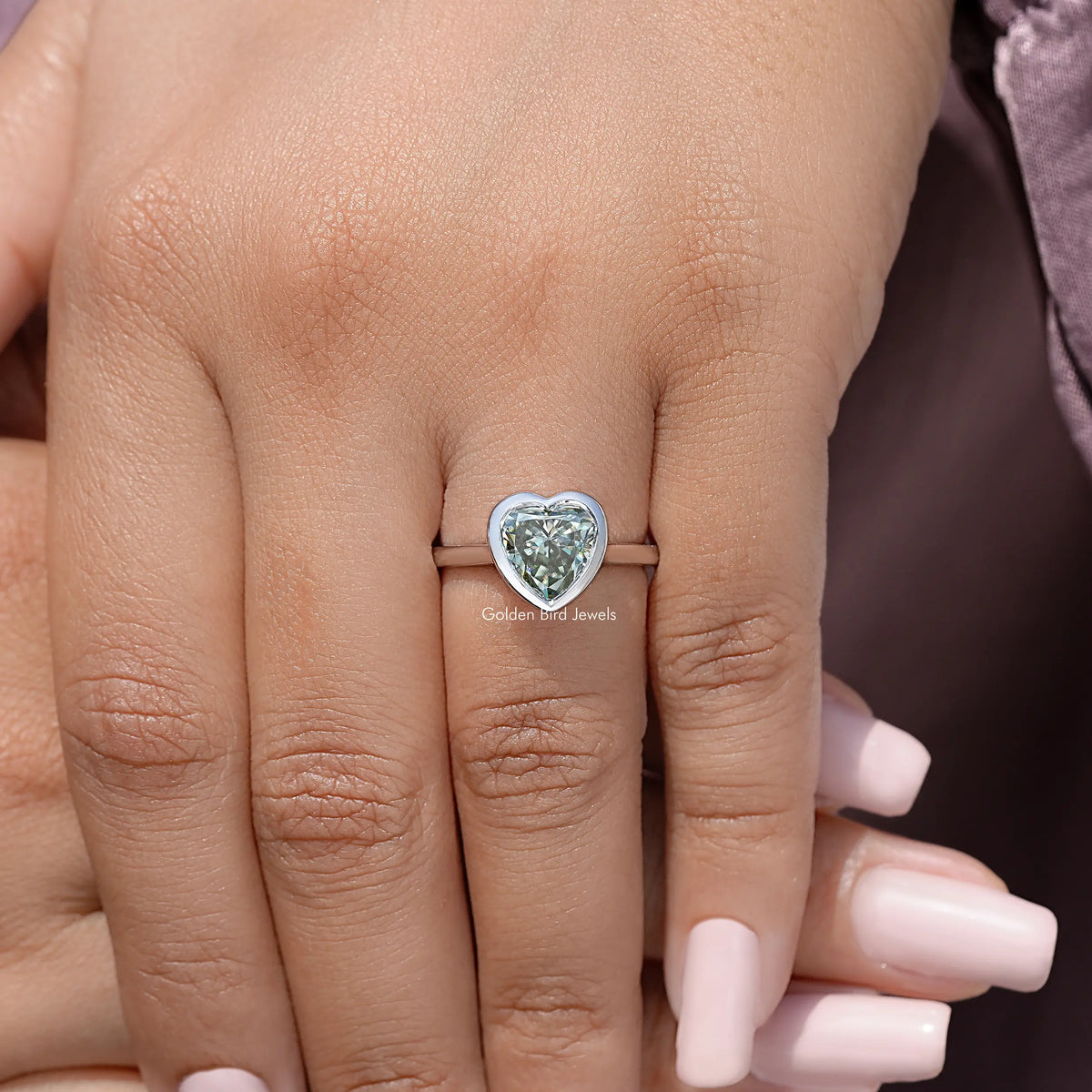 Heart-shaped moissanite bezel promise ring on hand, sterling silver band with heart stone