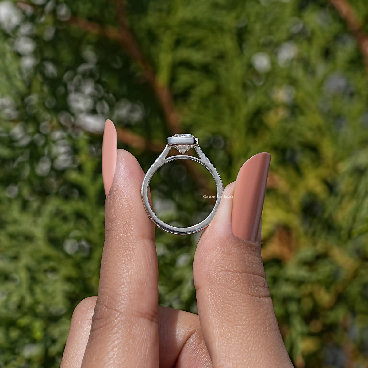 Emerald-cut moissanite solitaire ring, bezel-set center viewed from the front