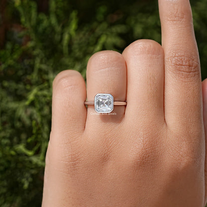 Sterling silver asscher-cut moissanite bezel-set engagement ring on finger