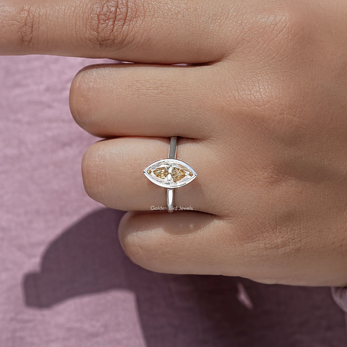 Marquise bezel ring with gold-toned marquise-cut center stone on silver band