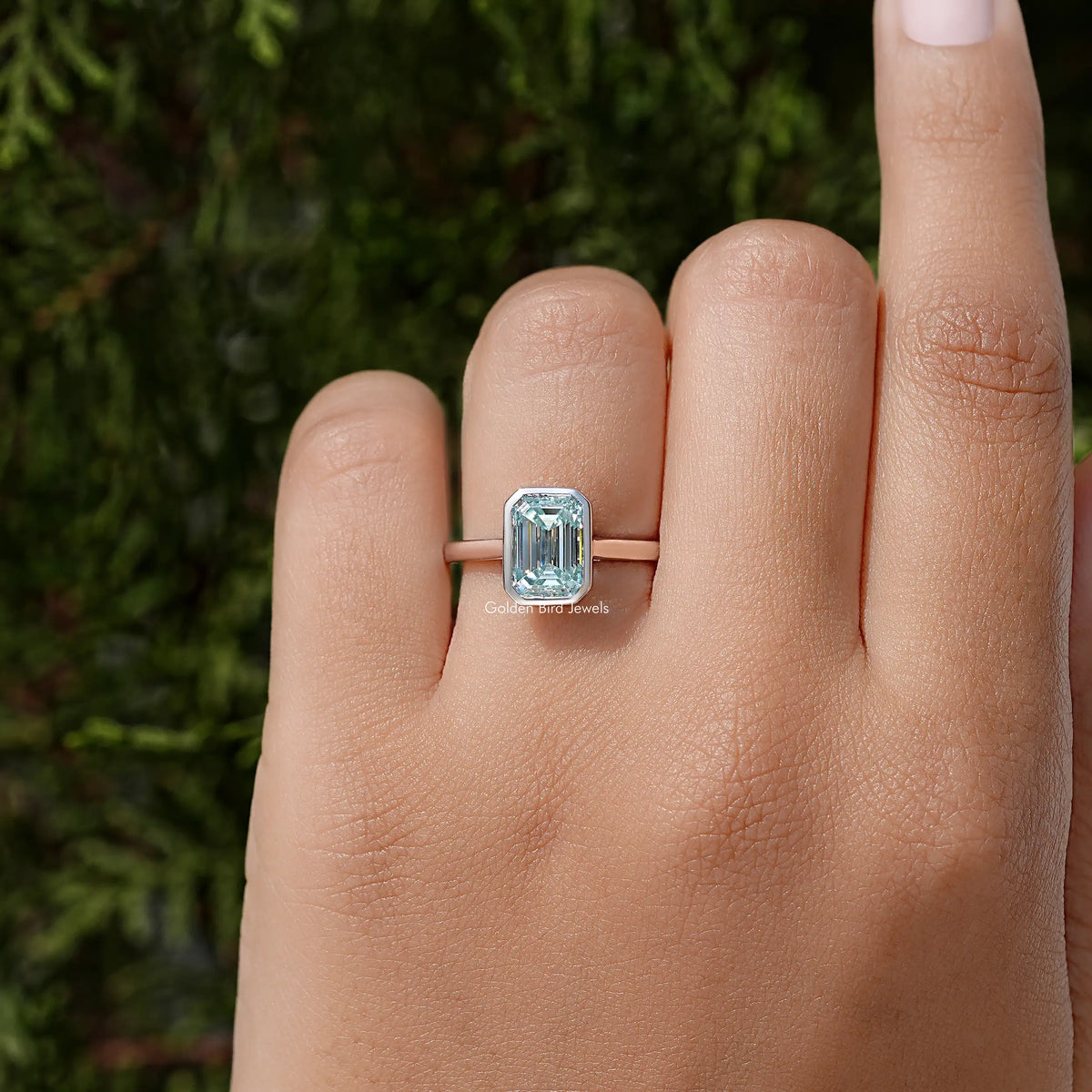 Blue emerald-cut moissanite solitaire ring with bezel setting in silver