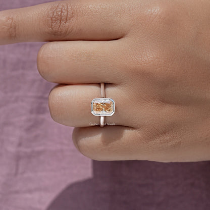 Radiant-cut solitaire ring with rose-gold bezel and square center stone