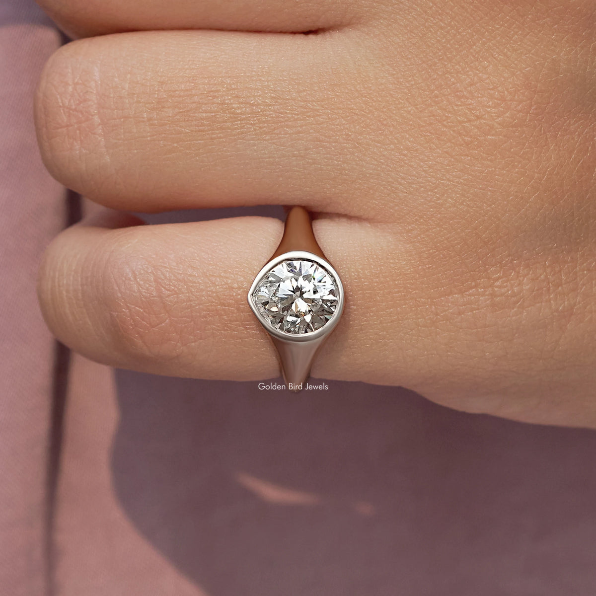 Silver bezel-set diamond engagement ring, round center view on finger close-up