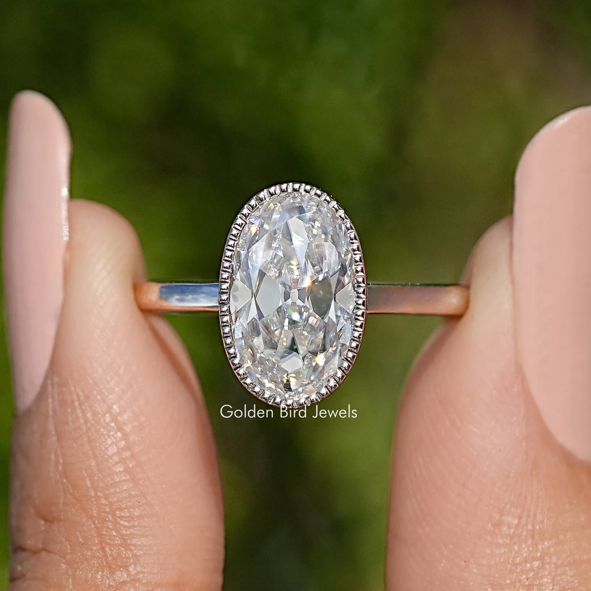 Oval bezel-set moissanite ring in silver, raised bezel around clear stone