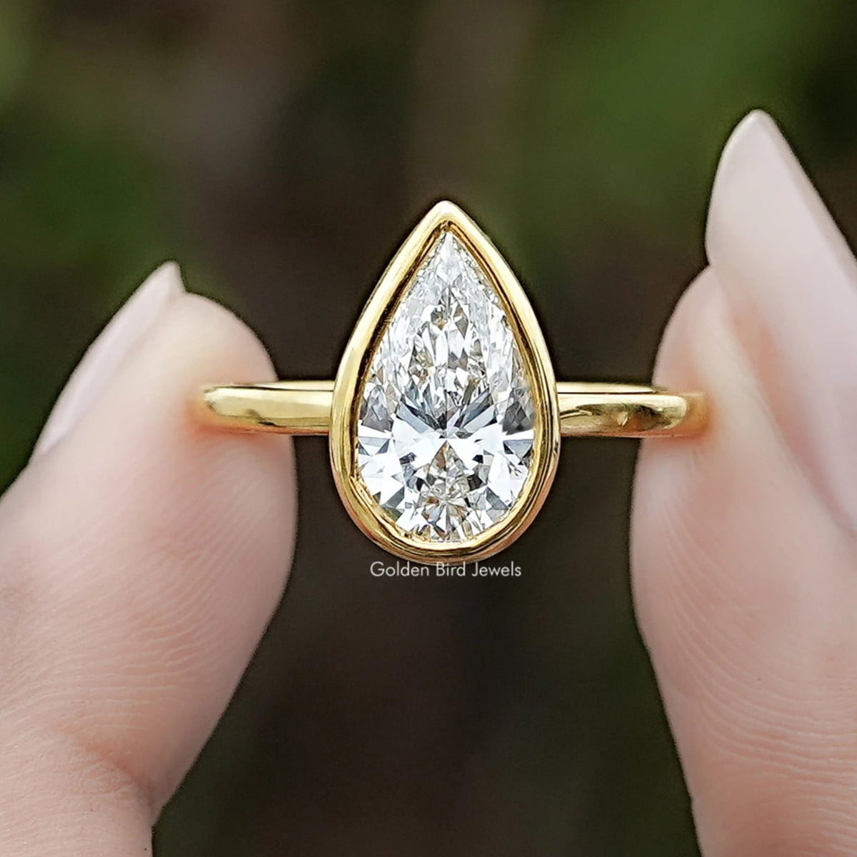Bezel Set Pear Cut Lab Diamond Solitaire Ring In Two Fingers