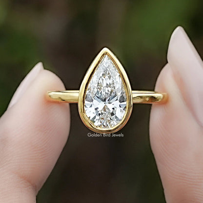 Bezel Set Pear Cut Lab Diamond Solitaire Ring In Two Fingers