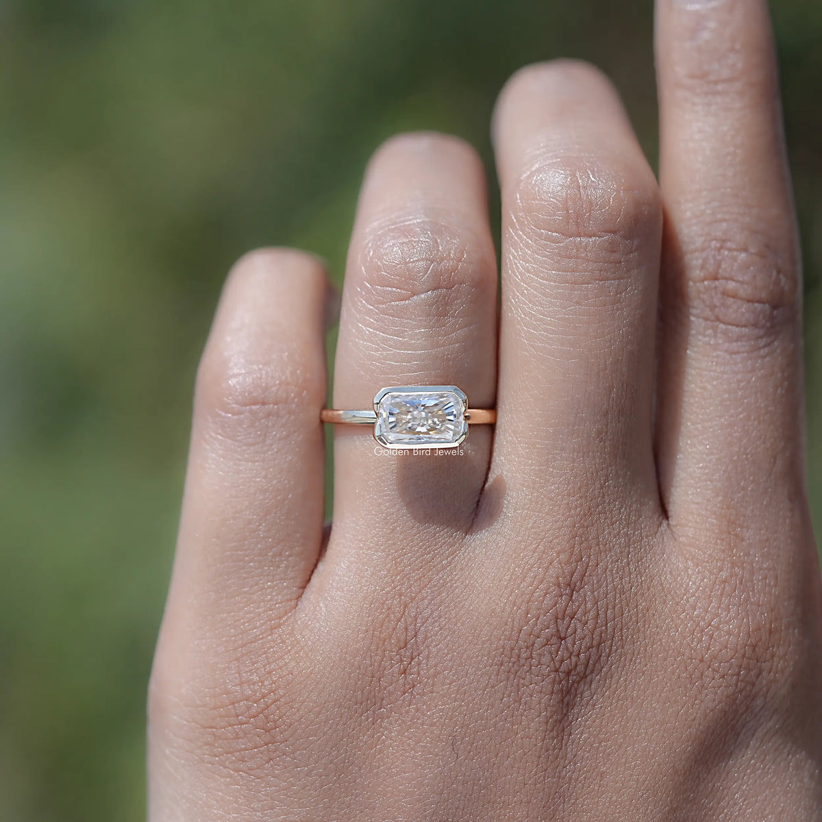 Gold-toned solitaire ring with radiant-cut moissanite in a half bezel setting