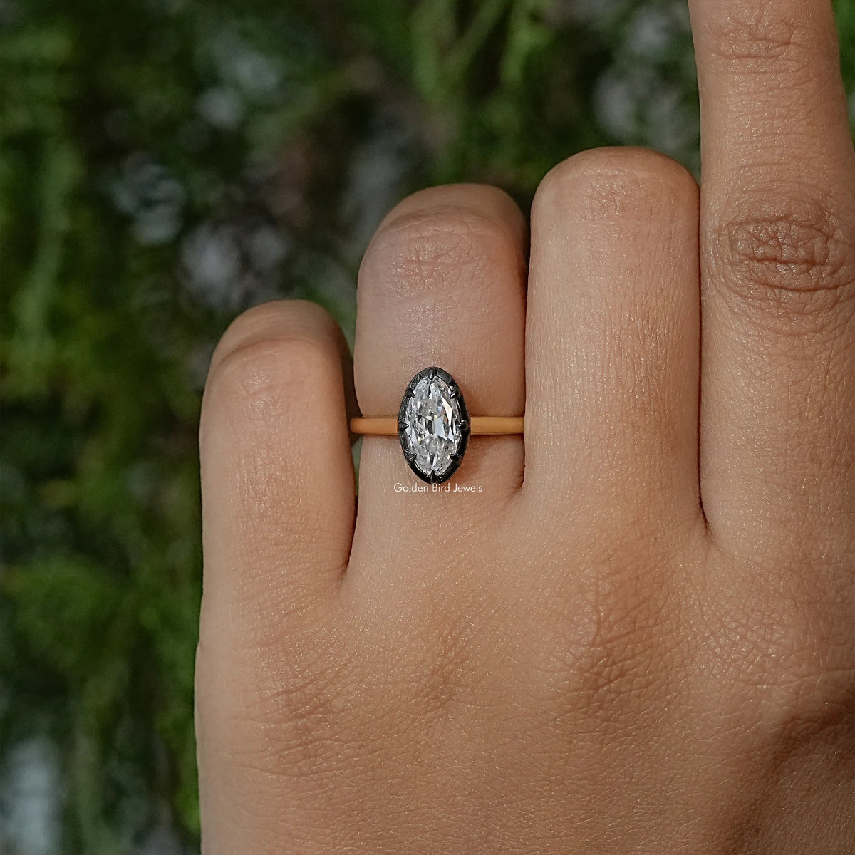 Oval moissanite solitaire ring with bezel setting on gold-tone band, front view