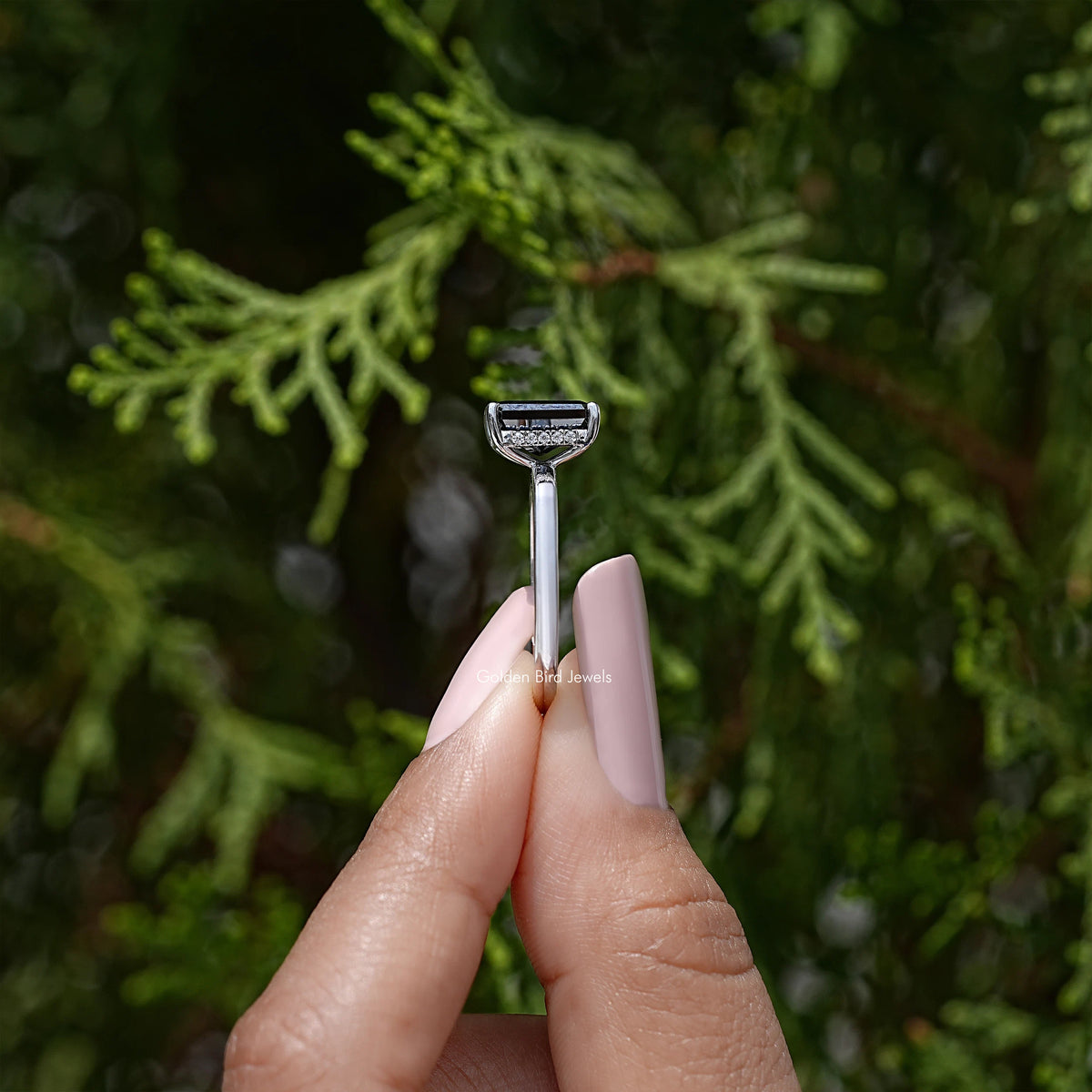 Silver ring top view with square black radiant-cut center stone and halo detail