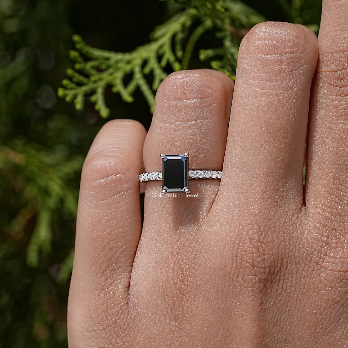 Black emerald-cut moissanite accent ring in sterling silver on a hand