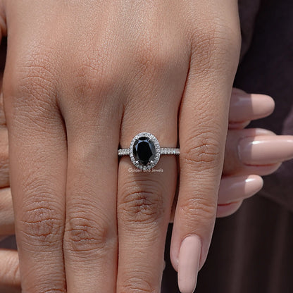 Oval black moissanite halo wedding ring on a hand