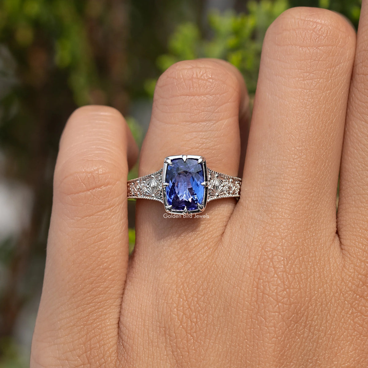 Tanzanite cushion-cut ring with blue center stone and filigree silver band