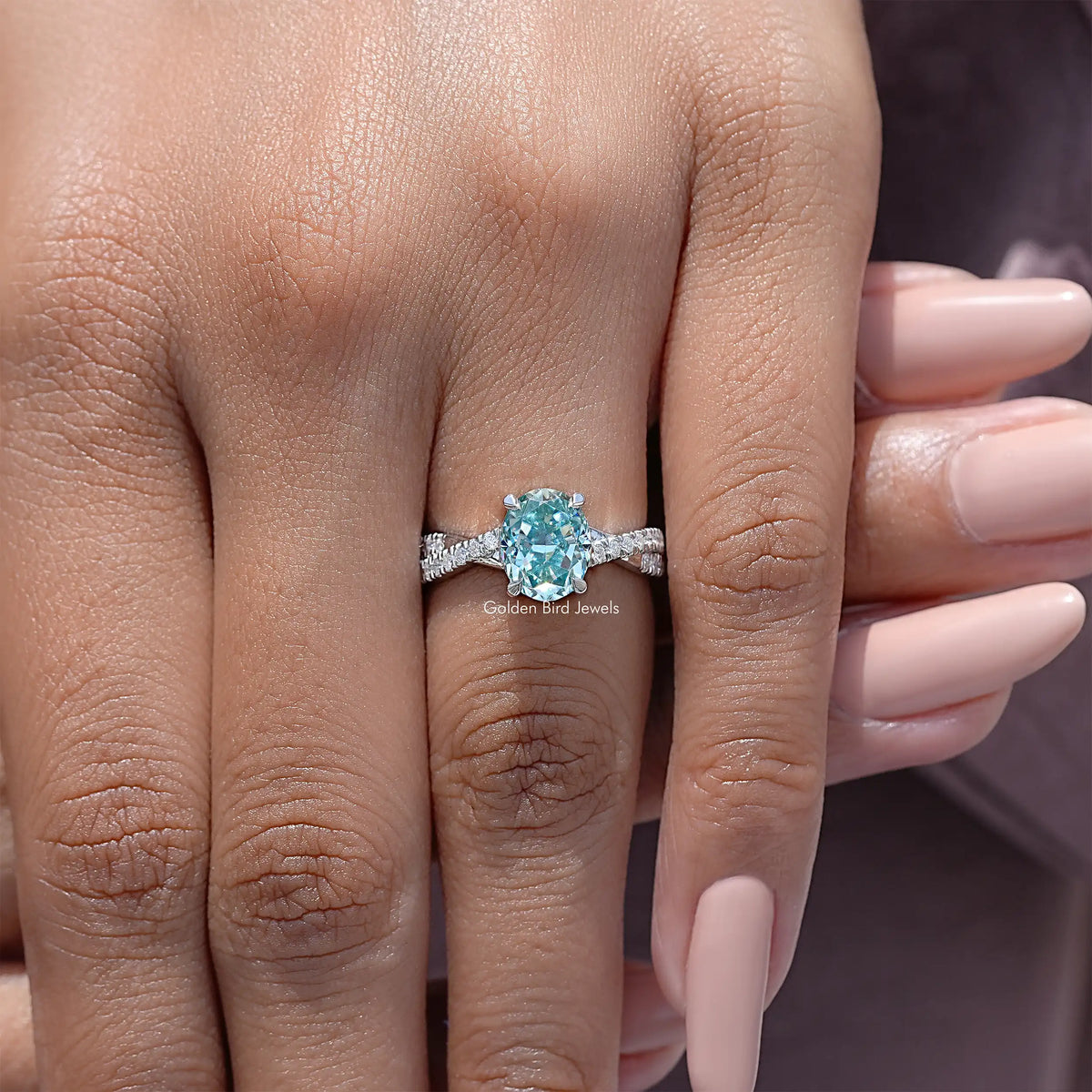 Sterling silver wedding ring with oval blue moissanite and pave side stones
