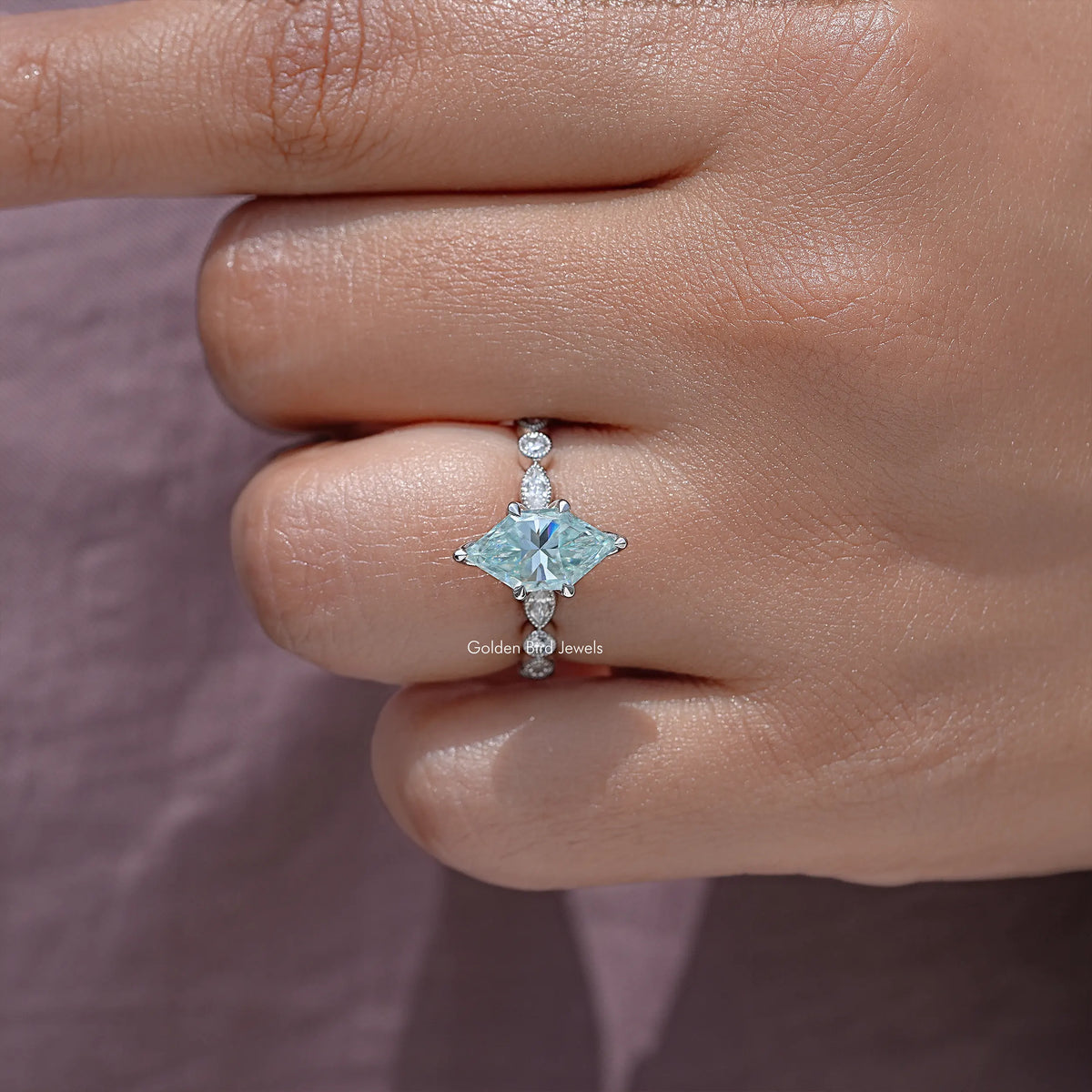 Sterling silver moissanite engagement ring close-up with blue marquise center and side studs