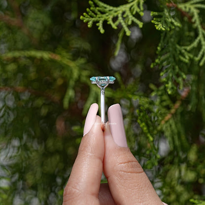 Marquise moissanite solitaire ring showing prongs and hidden halo, light blue