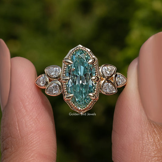 Blue oval moissanite ring with round side stones and ornate halo, close-up