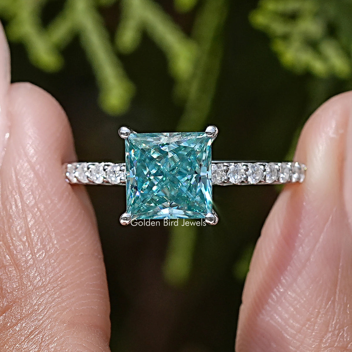 Princess cut moissanite solitaire ring with square blue center stone and pavé band