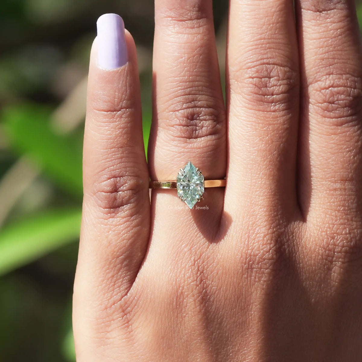 In finger view of solitaire moissanite engagement ring 