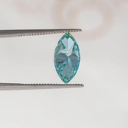Blue-green marquise-cut moissanite gemstone in tweezers, side profile