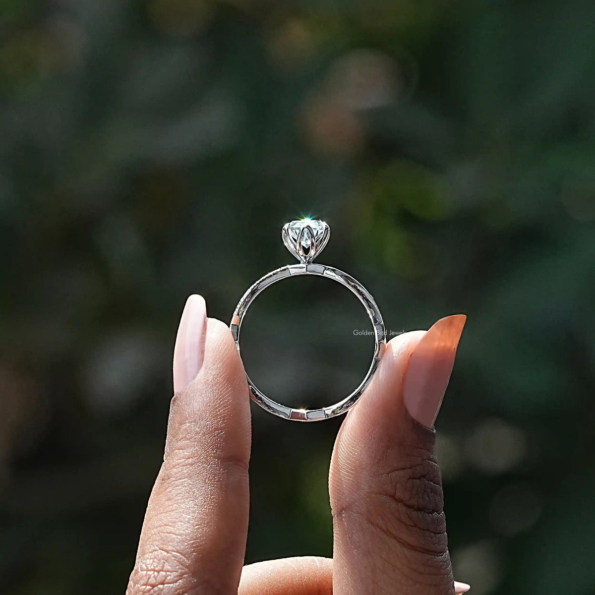 Back View of Twisted Shank Oval Cut Engagement Ring In two fingers