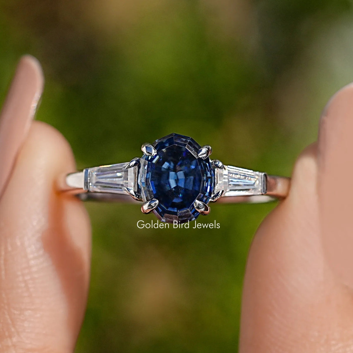Blue oval three-stone moissanite ring with baguette side stones, silver band