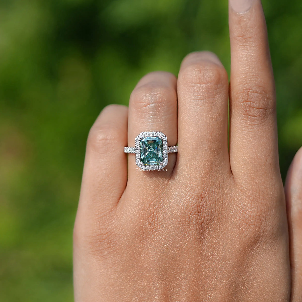 In finger front view of Blue Green Radiant Cut Moissanite engagement ring 