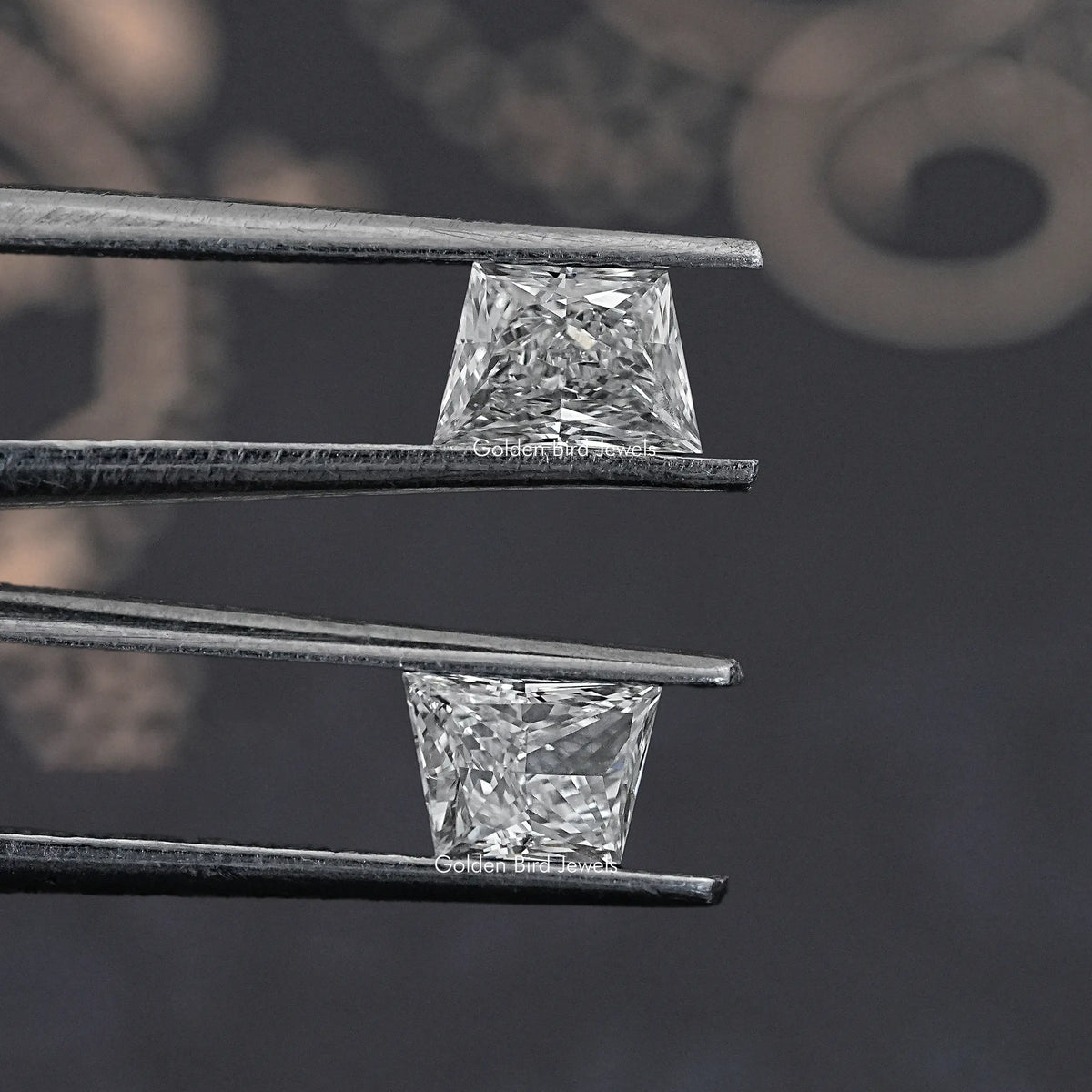 Trapezoid-cut lab diamond studs in silver-toned prongs, side view