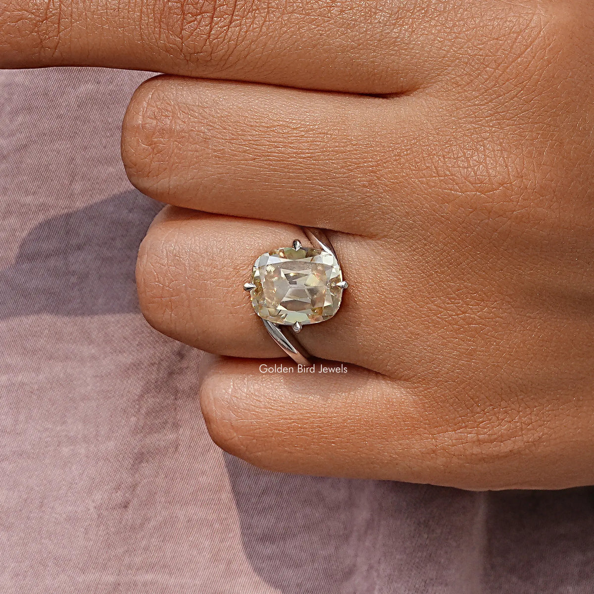 Cushion-cut clear moissanite solitaire ring on hand, sterling silver bypass shank