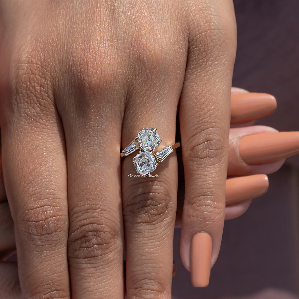 Close-up of white metal bypass engagement ring with cushion diamonds on bypass setting