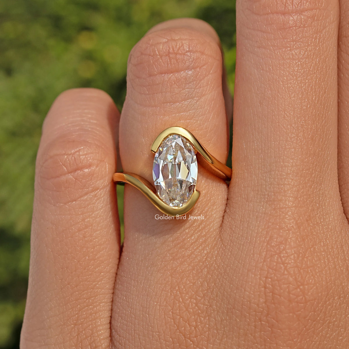 Gold-tone bypass solitaire ring with oval moissanite-style center stone