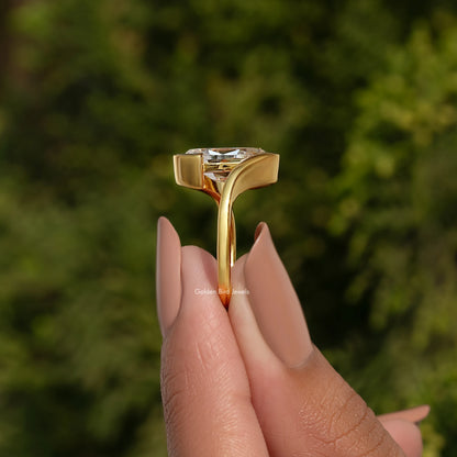 Gold-tone bypass solitaire ring showing prong-set oval stone from above