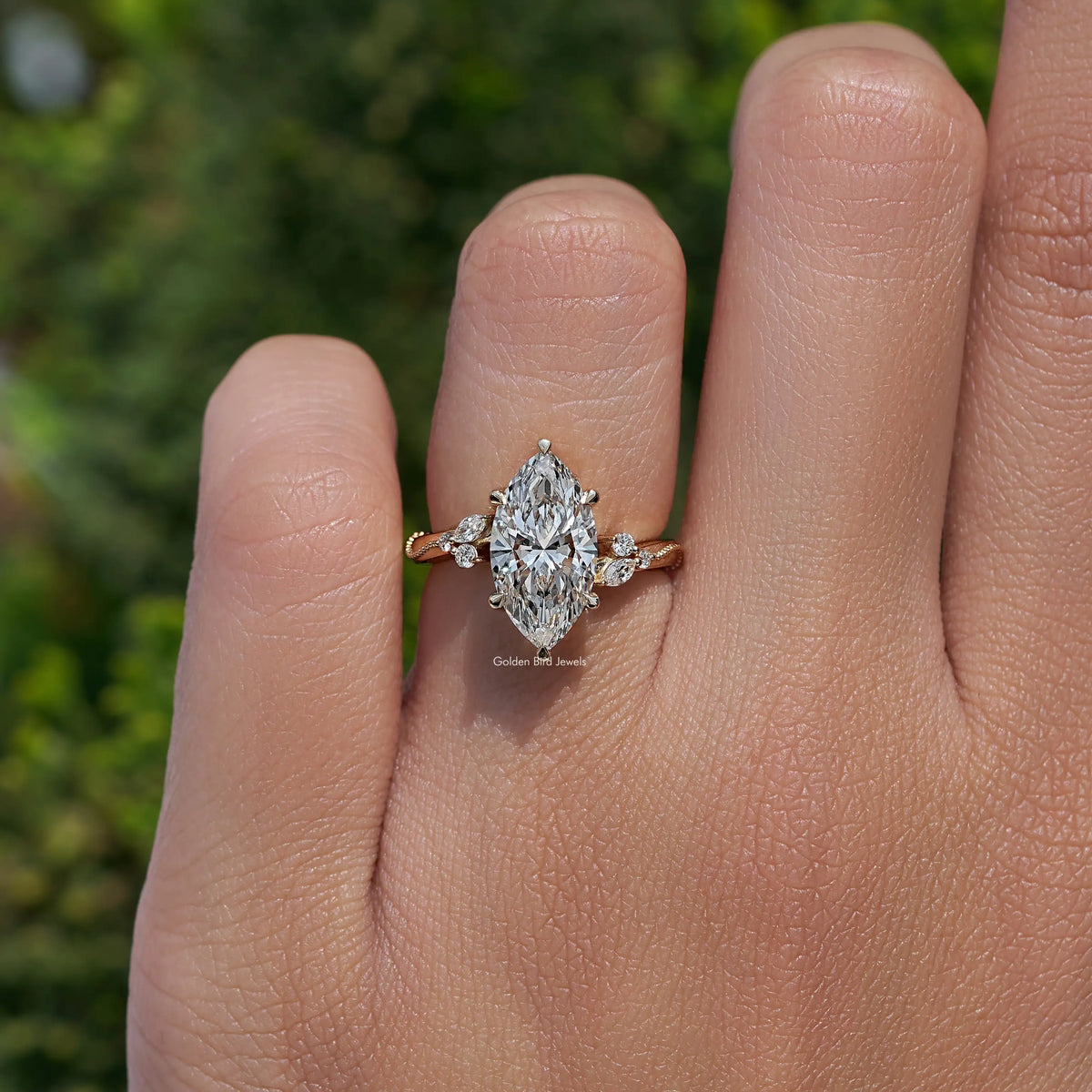 Marquise-cut lab-grown accent ring on hand with round side stones