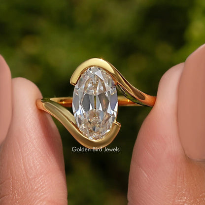 Gold-tone bypass solitaire ring with large oval center stone, side profile view
