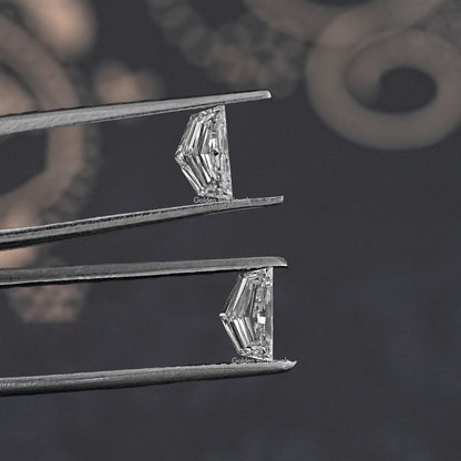 Cadillac-shaped lab-grown diamond pair, clear step-cut stones held by tweezers