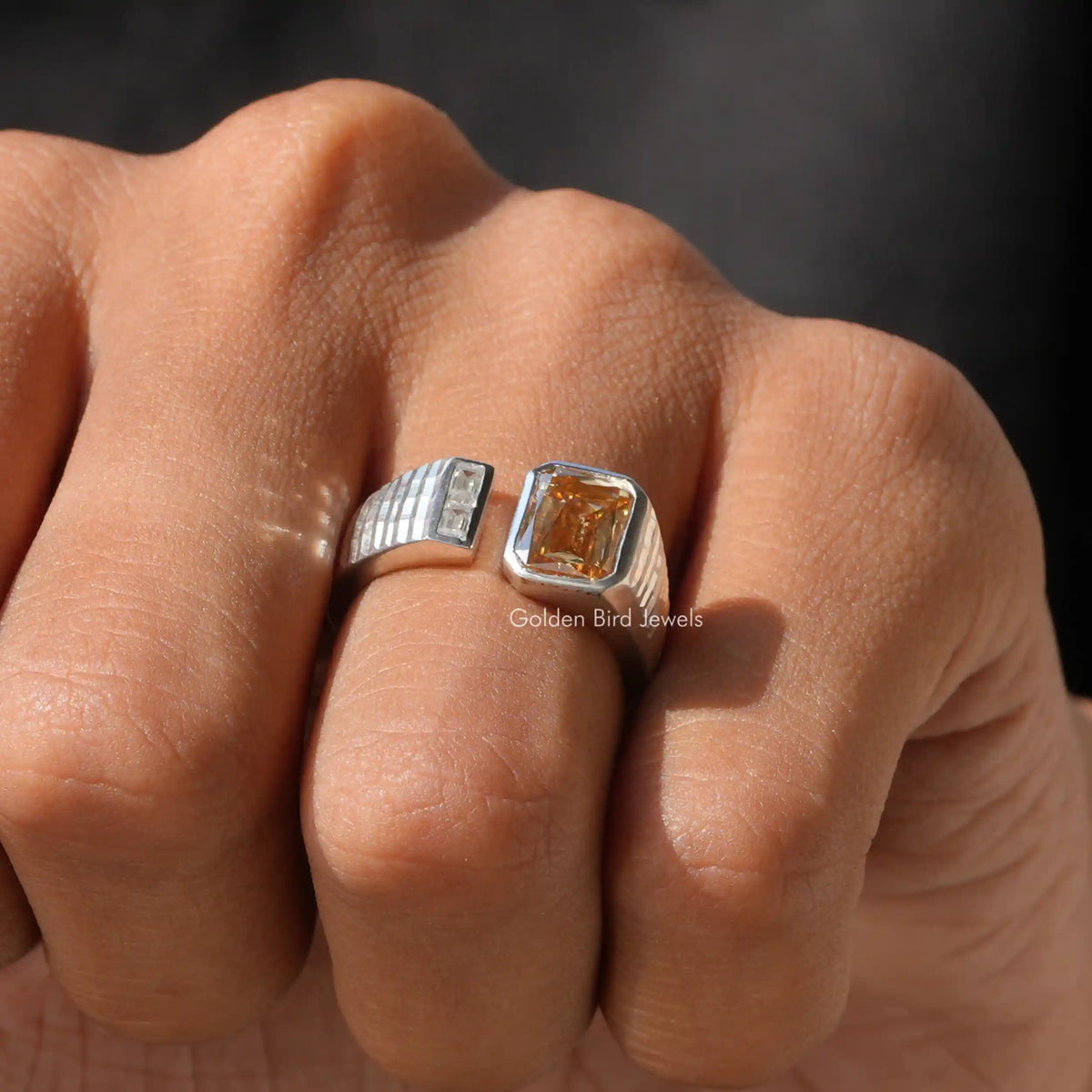 Two-stone open cuff ring close-up: clear baguette-like stone and amber square stone