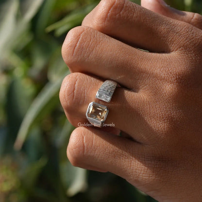 Open cuff ring on finger, silver bands with square clear center and amber stone