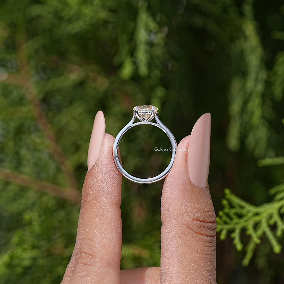 Oval cut moissanite solitaire ring showing round profile with four-prong center.