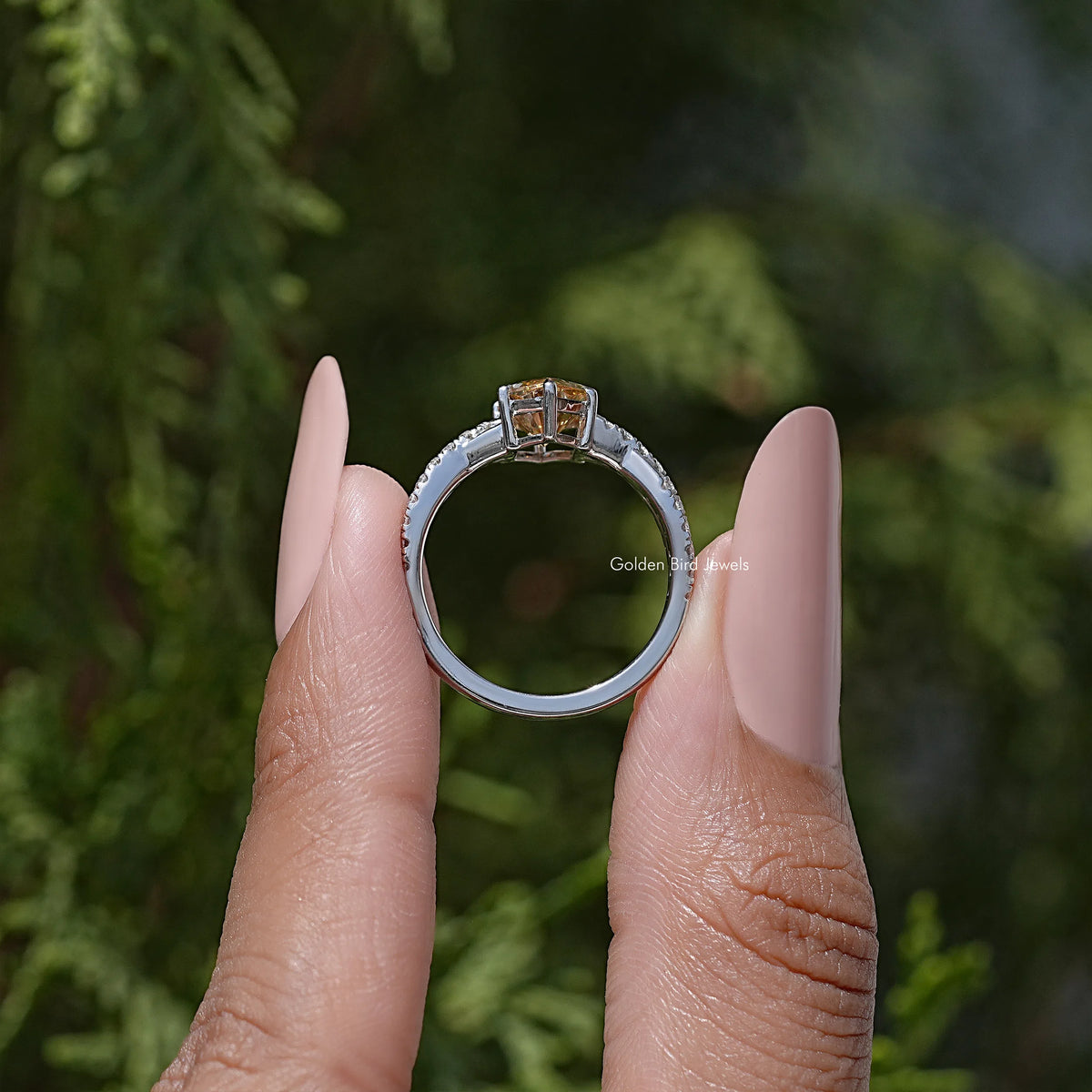 Marquise-cut gemstone ring in sterling silver, held between two fingers