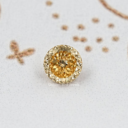 Close-up round golden-yellow moissanite gemstone, full face faceted pattern