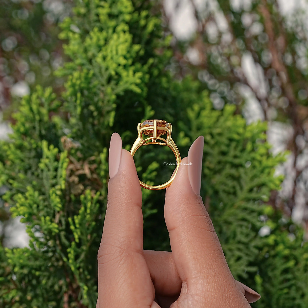 Solitaire cushion-cut moissanite ring with gold setting and golden center stone, side view