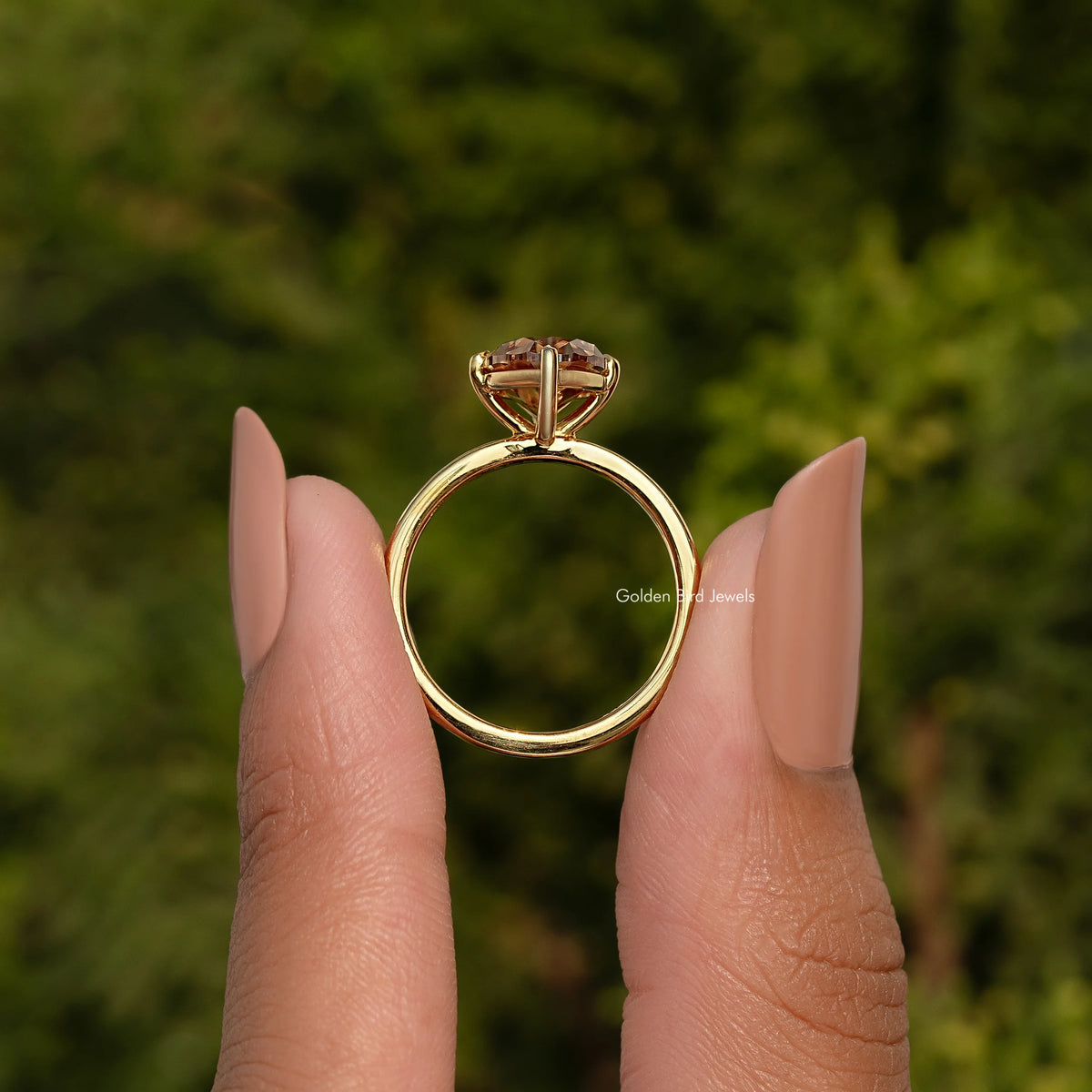 Oval champagne moissanite solitaire ring with four-prong setting, gold-tone band