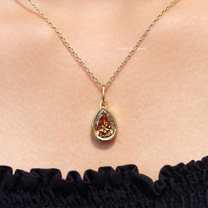 Gold teardrop pendant necklace featuring a champagne-colored pear-cut gemstone
