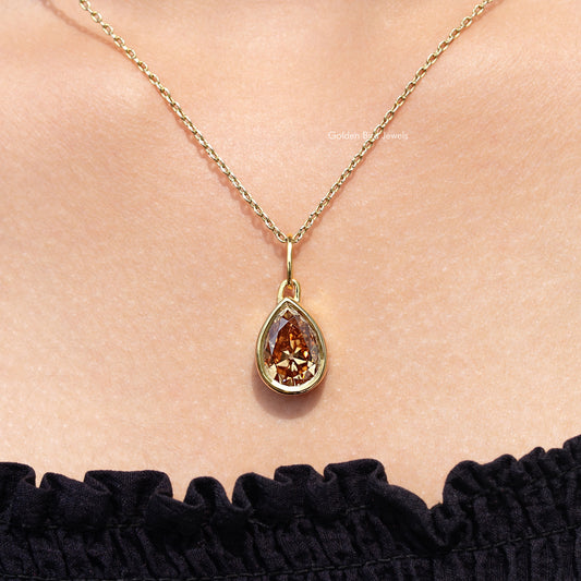 Gold teardrop pendant necklace featuring a champagne-colored pear-cut gemstone
