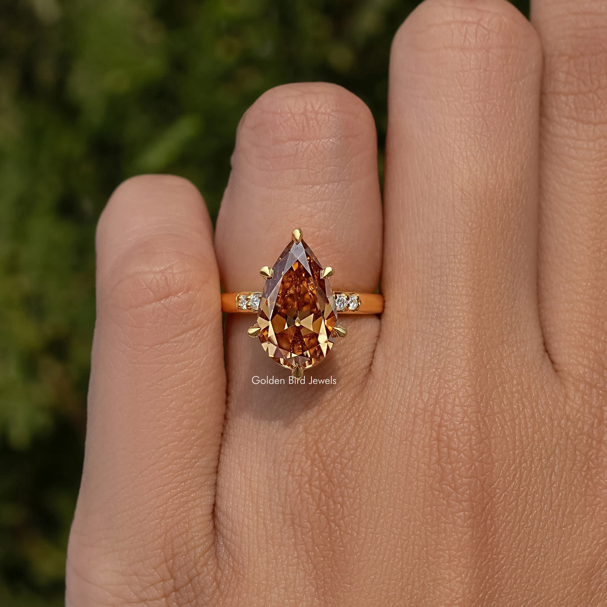 Gold ring with large pear-cut cognac center stone and tiny square side stones