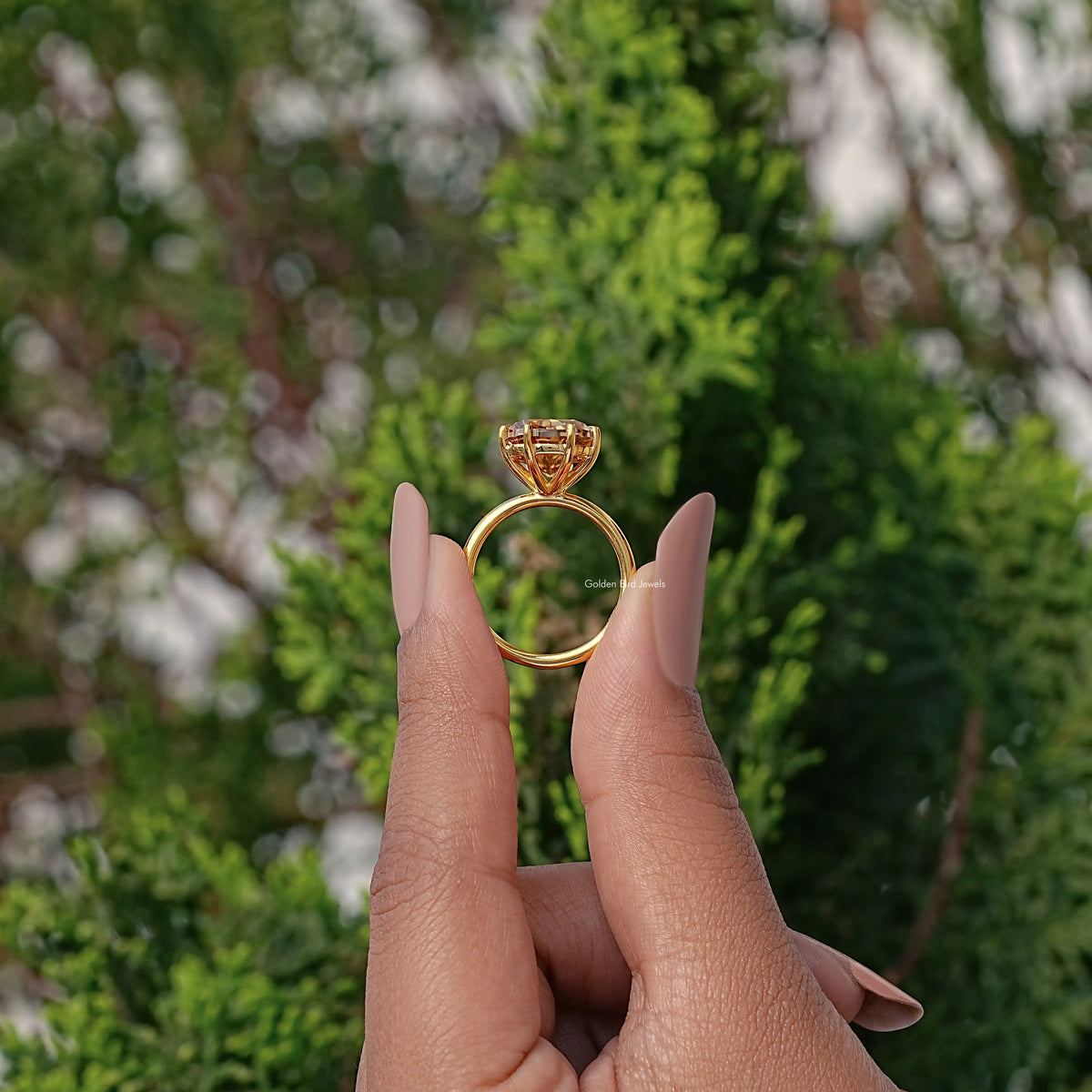 Gold-toned cushion-cut moissanite engagement ring with decorative halo prongs