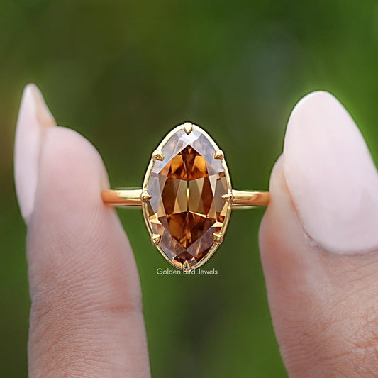Gold-tone solitaire ring with oval champagne center stone and scalloped prong halo