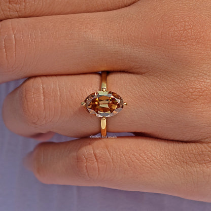 Champagne oval moissanite solitaire ring, close-up of oval stone and prong setting